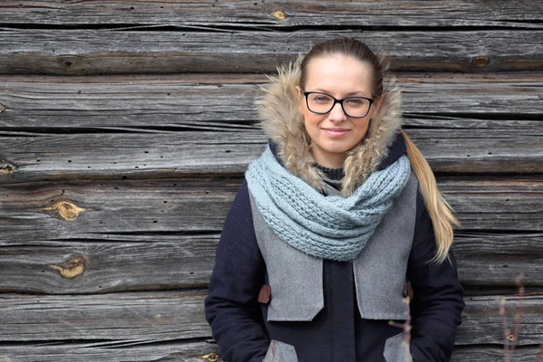 Beautiful girl on the background of a wooden wall — Stock Photo, Image