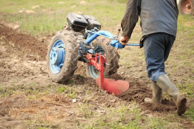 Bir adam bir motor bloğu olan bir alana pulluk