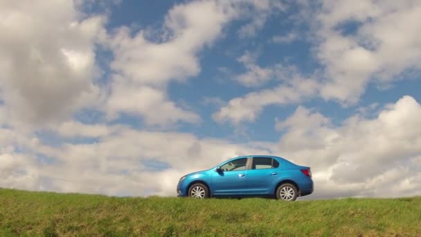 Homel, Wit-Rusland - 16 April 2017: de auto is geparkeerd in het veld tegen de hemel met wolken — Stockvideo