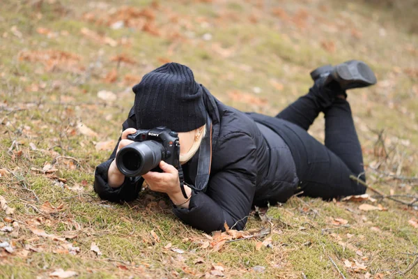 Gomel, Weißrussland - 12. April 2017: Eine Fotografin fotografiert am Boden liegend — Stockfoto