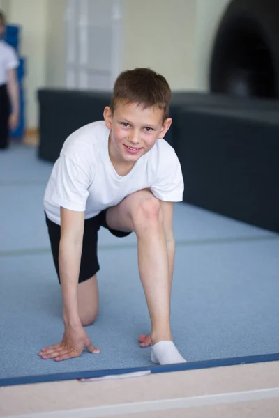 Молодой человек выполняет гимнастические упражнения в гимназии . — стоковое фото