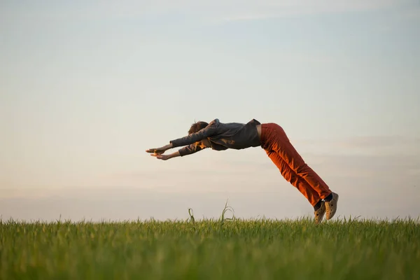 Подросток летит над полем на закате . — стоковое фото