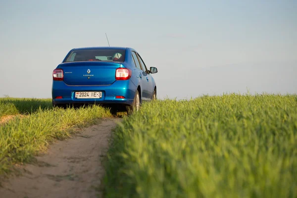 GOMEL, BELARUS - 6 May 2017: blue car Renault Logan parked in a field on a country road. — Stock Photo, Image