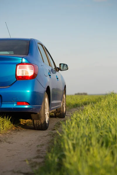 Gomel, Vitryssland - 6 maj 2017: blå bil Renault Logan parkerad i ett fält på en landsväg. — Stockfoto