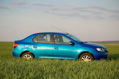 Gomel, Beyaz Rusya - 6 Mayıs 2017: mavi araba Renault Logan park etmiş bir ülke yolunda bir alanda.