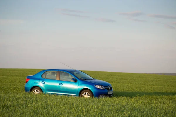 GOMEL, BELARUS - 6 May 2017: blue car Renault Logan parked in a field on a country road. — Stock Photo, Image