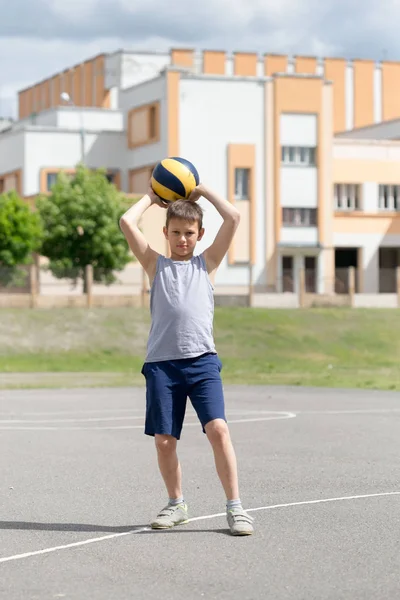 Teenager in T-Shirt und kurzer Hose, der mit einem Ball spielt — Stockfoto