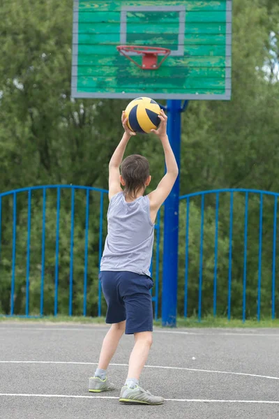 Teenager in T-Shirt und kurzer Hose wirft den Ball in den Ring — Stockfoto