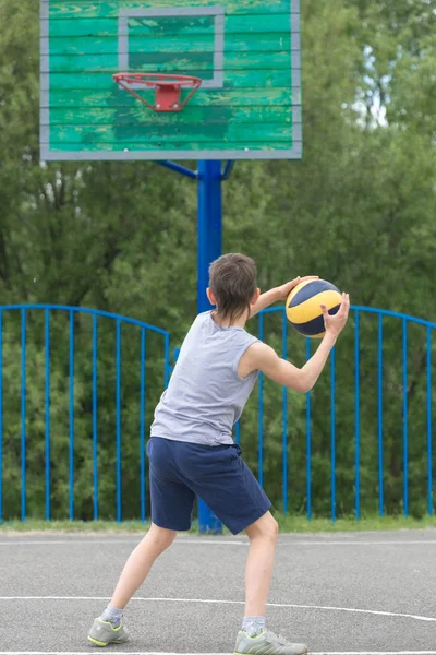 Teenager in T-Shirt und kurzer Hose wirft den Ball in den Ring — Stockfoto