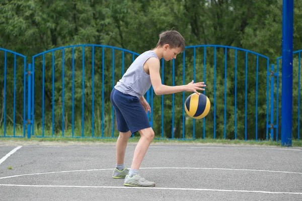 Teenager in T-Shirt und kurzer Hose, der mit einem Ball spielt — Stockfoto