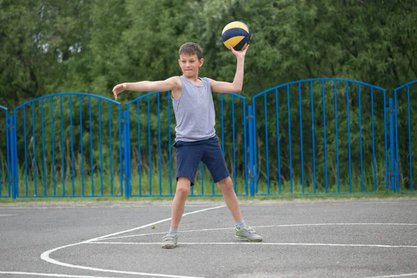Подросток в футболке и шортах, играющий с мячом — стоковое фото