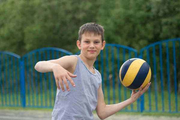 Έφηβος σε ένα μπλουζάκι και σορτς που παίζει με μια μπάλα — Φωτογραφία Αρχείου