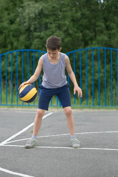 Adolescente en una camiseta y pantalones cortos jugando con una pelota — Foto de Stock