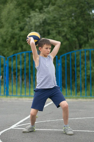 Teenager in T-Shirt und kurzer Hose, der mit einem Ball spielt — Stockfoto