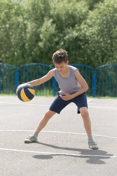 Teenager in T-Shirt und kurzer Hose, der mit einem Ball spielt — Stockfoto