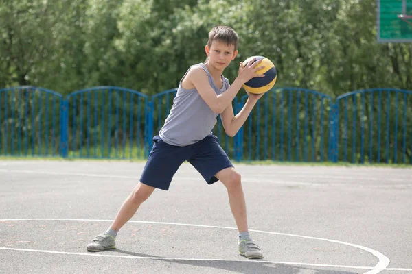 Adolescente em uma camiseta e shorts brincando com uma bola — Fotografia de Stock