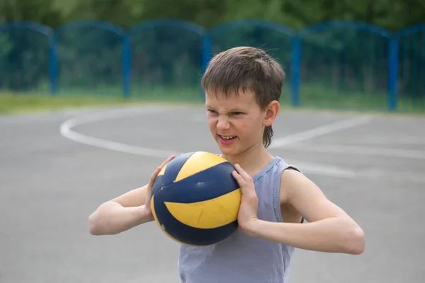 Підліток у жилеті тримає м'яч у руці — стокове фото