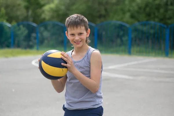 Un adolescente en un chaleco sostiene una pelota en su mano — Foto de Stock