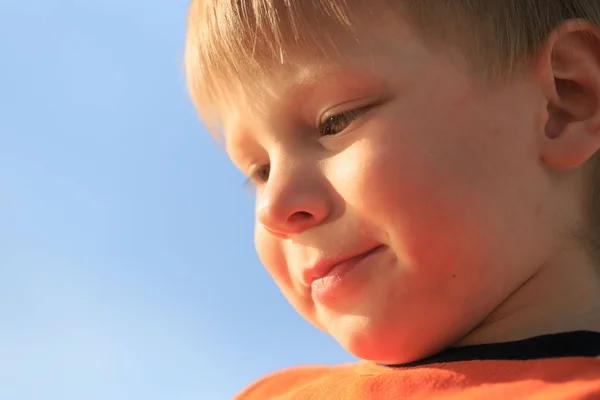 Nagy portré egy gyermek ellen az égen a lenyugvó nap sugaraiban — Stock Fotó