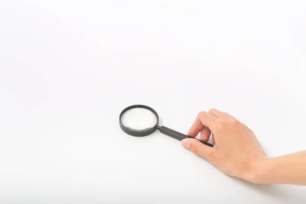 Female hands on white background with magnifier — Stock Photo, Image