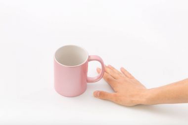 Bir fincan beyaz bir zemin üzerine eller