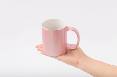 Bir fincan beyaz bir zemin üzerine eller