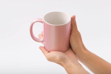 Bir fincan beyaz bir zemin üzerine eller