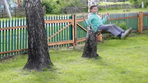 Çocuk ağaç arasında bir salıncak üzerinde sürme — Stok video