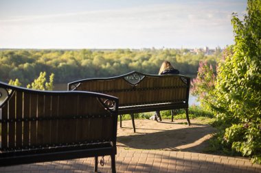 Kız parkta bankta bir kitap okuma