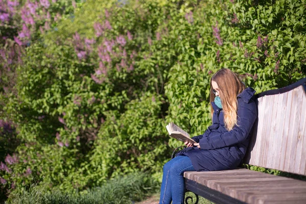 Girl reading a book in the park on the bench — Stock Photo, Image