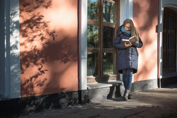 La chica está leyendo un libro sentado junto a la ventana — Foto de Stock