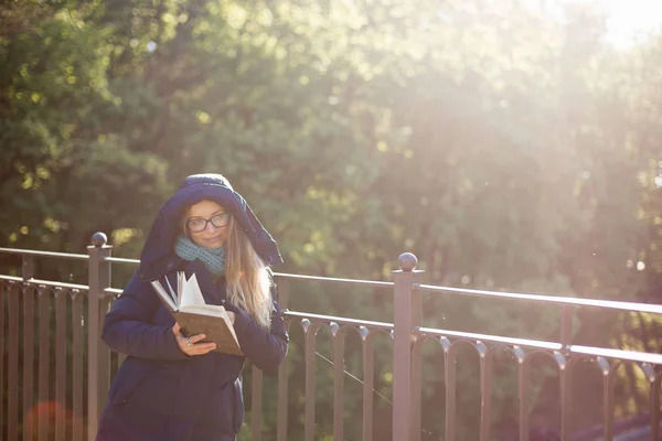 Счастливая девушка читает книгу за перилами . — стоковое фото