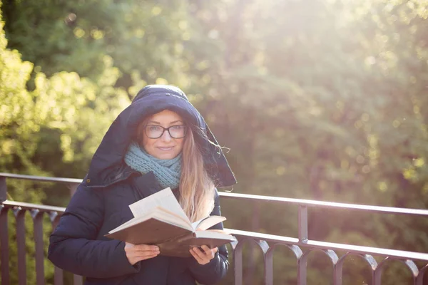 Щаслива дівчина читає книгу на перилах . — стокове фото