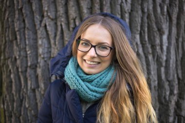 Happy girl standing by the big tree clipart