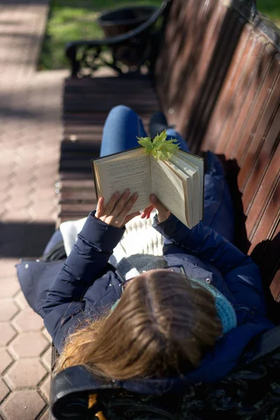 Дівчина читає книгу в парку на лавці — стокове фото