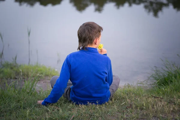 Подросток сидит на берегу озера . — стоковое фото