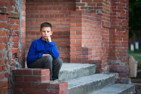 Мальчик-подросток сидит дома на крыльце — стоковое фото