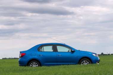 Gomel, Beyaz Rusya - 24 Mayıs 2017: mavi araba yeşil sahada duruyor.