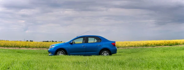 Gomel, Wit-Rusland - 24 mei 2017: de blauwe auto wordt geparkeerd op het groene veld. — Stockfoto