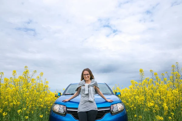 Όμορφο κορίτσι στέκεται το αυτοκίνητο σε κίτρινο πεδίο — Φωτογραφία Αρχείου