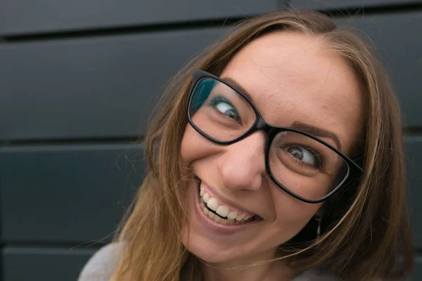 Μεγάλη πορτρέτο του ένα κορίτσι με τα γυαλιά σε ένα γκρίζο φόντο — Φωτογραφία Αρχείου