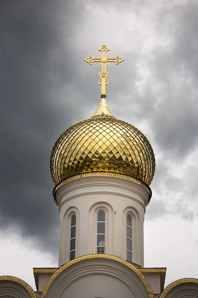 Kilisenin fırtınalı gökyüzünde altın kubbesi. — Stok fotoğraf