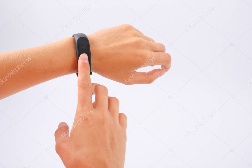 Fitness bracelet and phone in female hands on white