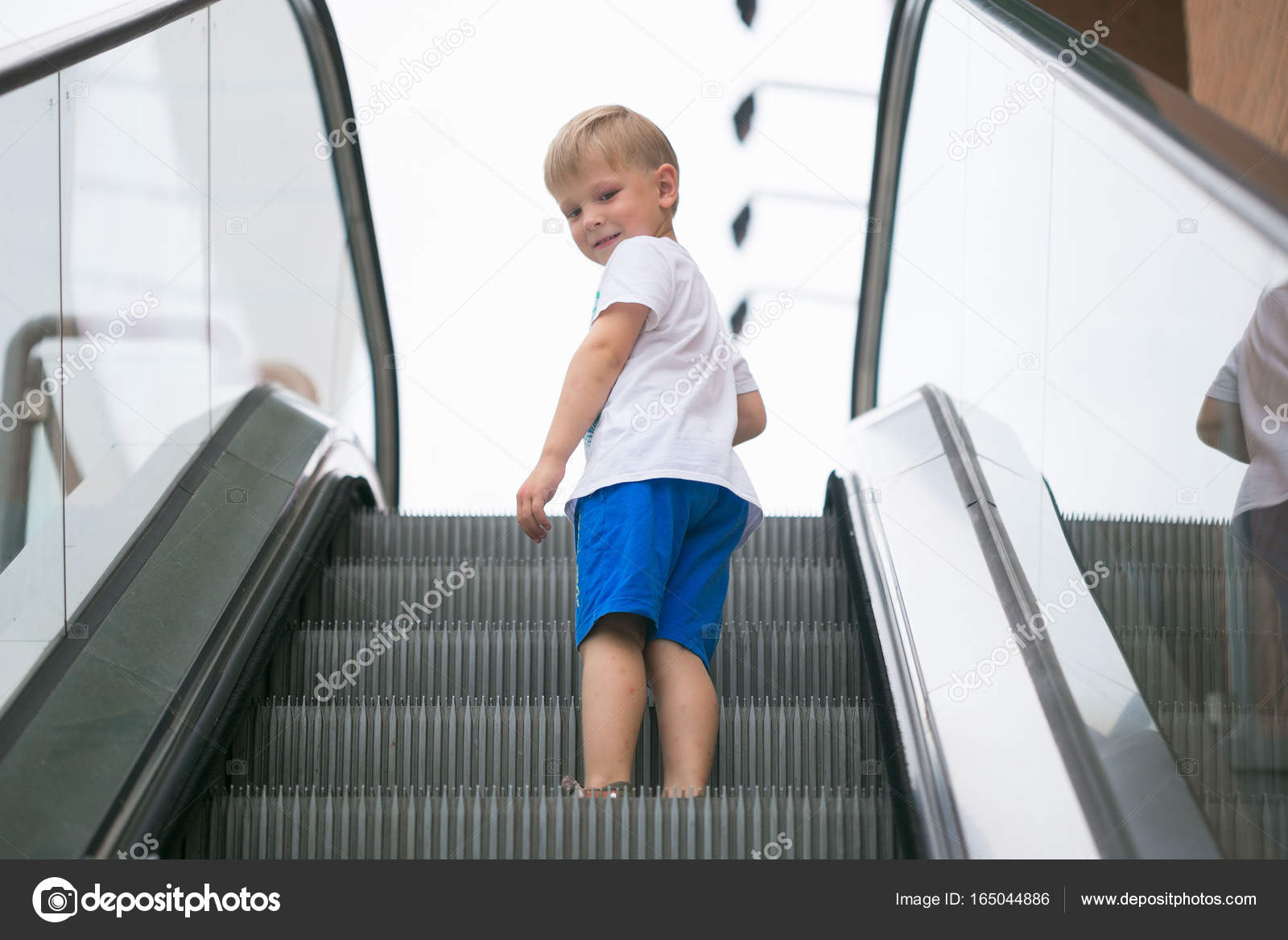 Little boy riding an escalator one dangerous. — Stock Photo © makALEX