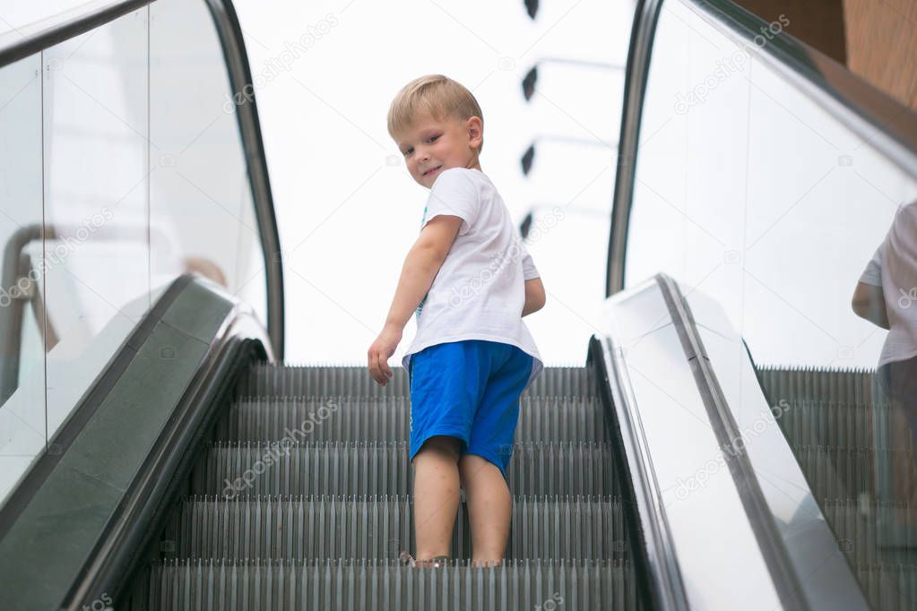 Little boy riding an escalator one dangerous.