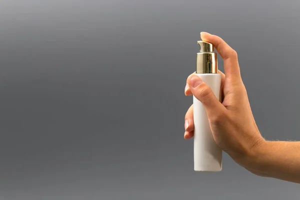 Mini pulverizador de botella sobre fondo gris en la mano — Foto de Stock