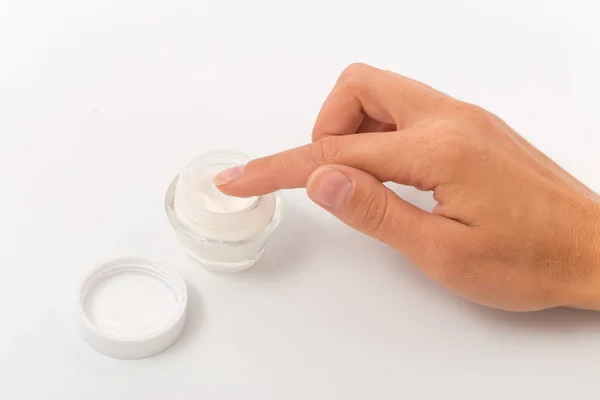Crema blanca en un frasco de vidrio pequeño en manos femeninas . — Foto de Stock