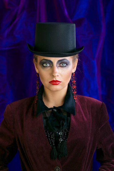 фея театрального искусства визажистка в шляпе цилиндра на фиолетовом фоне
.
