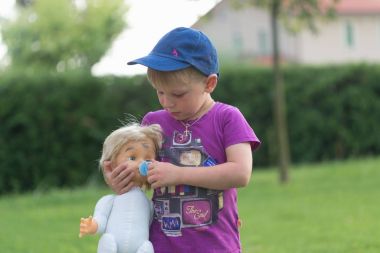 Montagnana, İtalya - 6 Ağustos 2017: 4 yıl evin avlusunda bir bebek ile oynayan bir çocuk.