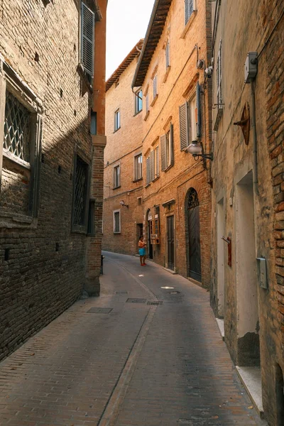 Urbino, Italia - 9 de agosto de 2017: Una pequeña calle en el casco antiguo de Urbino. día soleado. — Foto de Stock